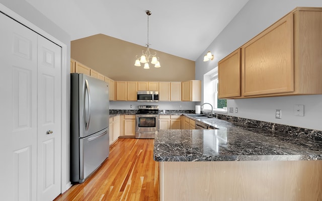 kitchen featuring light wood-type flooring, light brown cabinetry, dark stone countertops, appliances with stainless steel finishes, and a peninsula