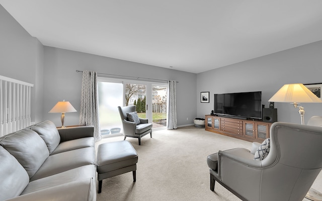 living area featuring light carpet and baseboards