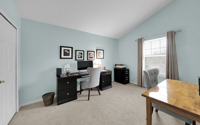 office area with vaulted ceiling, light colored carpet, and baseboards