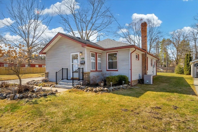 bungalow-style home featuring cooling unit, a chimney, a front lawn, and fence