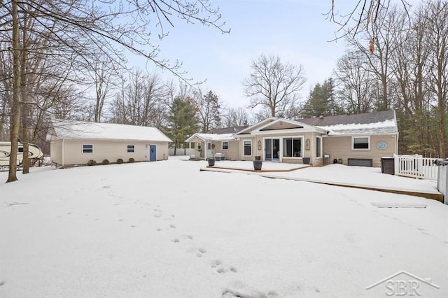 snow covered rear of property with a garage