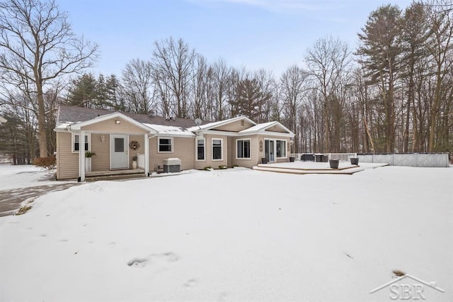 snow covered property with a deck and central AC unit