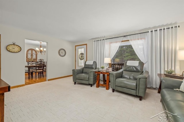 sitting room featuring light colored carpet, baseboards, and an inviting chandelier