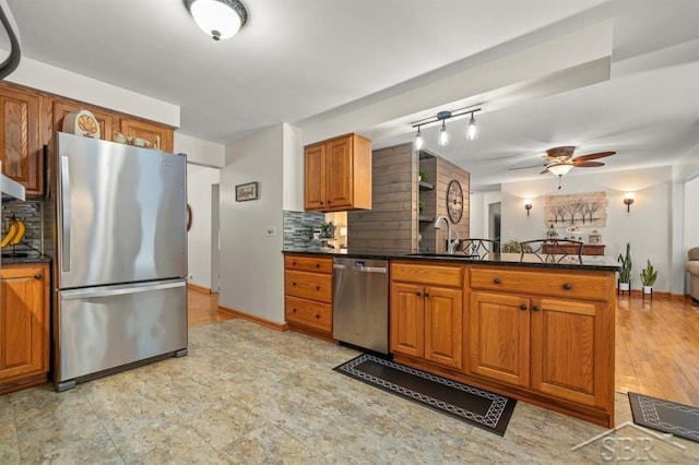 kitchen with appliances with stainless steel finishes, dark countertops, and brown cabinetry