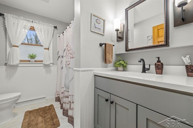 full bath with toilet, a wainscoted wall, a baseboard radiator, a shower with curtain, and vanity