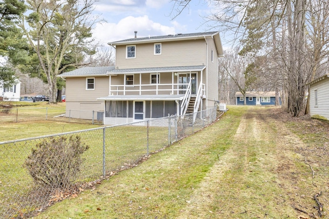 rear view of property with a sunroom, a fenced backyard, stairs, and a yard