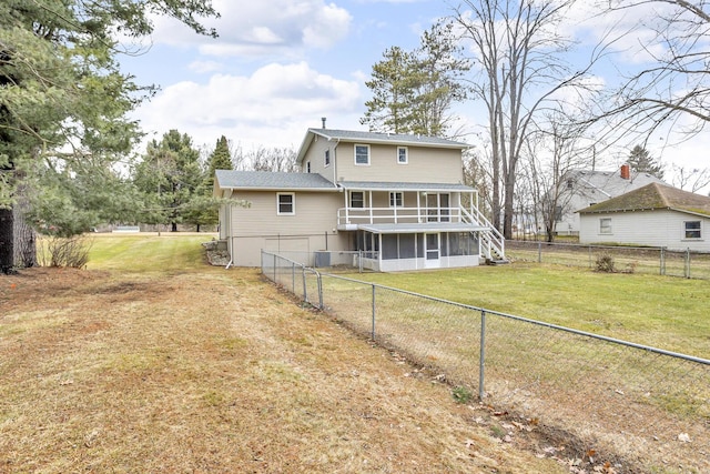 back of house with a yard, a fenced backyard, and a sunroom