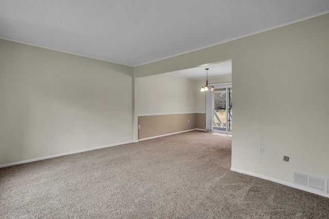 carpeted empty room with baseboards, visible vents, a notable chandelier, and ornamental molding