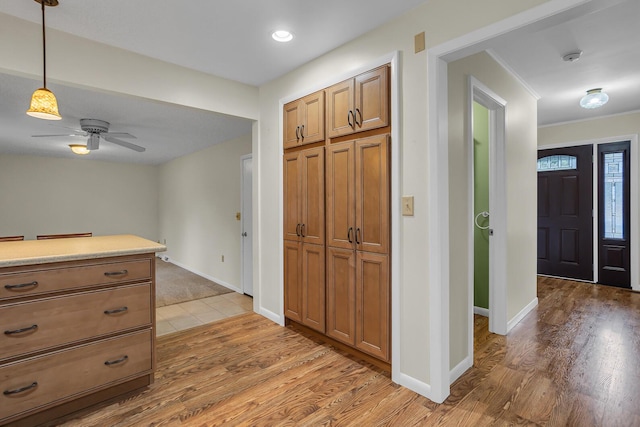 entrance foyer with wood finished floors, a ceiling fan, and baseboards