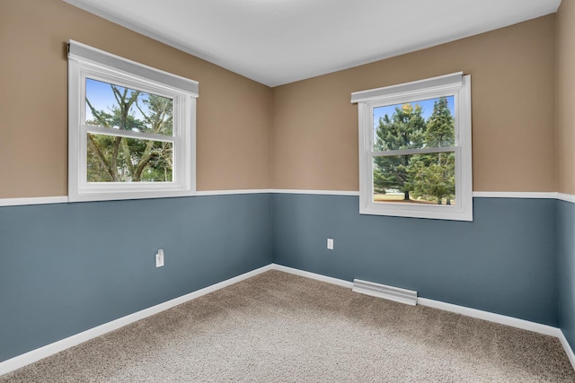 unfurnished room featuring carpet floors, visible vents, and baseboards