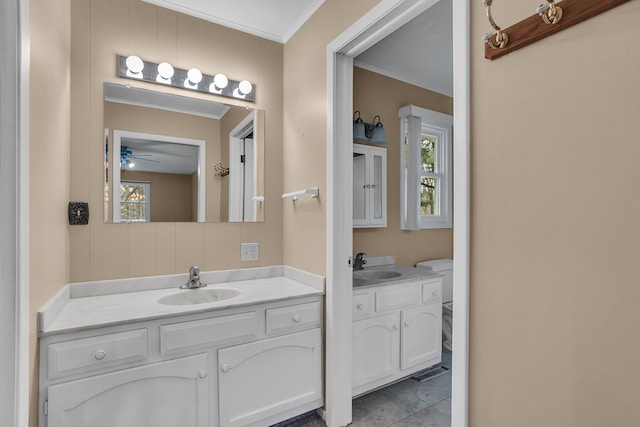 bathroom featuring plenty of natural light, two vanities, and a sink