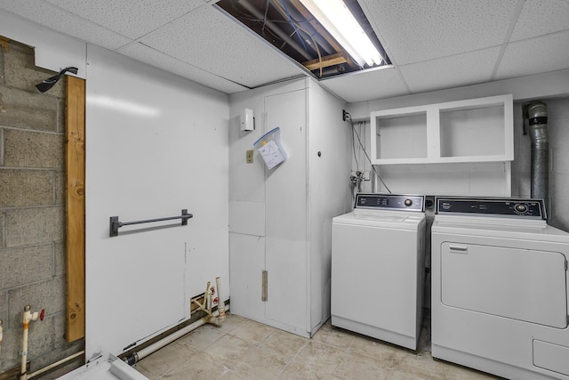 laundry area featuring concrete block wall, laundry area, and washer and dryer