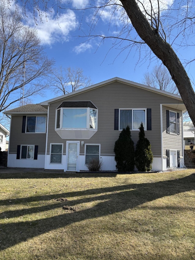 view of front of property featuring a front lawn and central AC