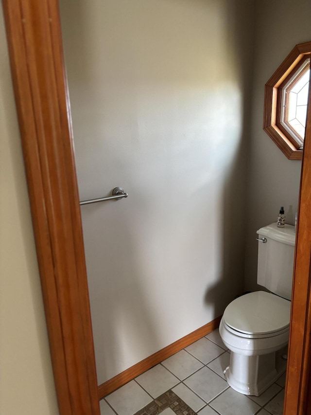 bathroom with tile patterned flooring, toilet, and baseboards