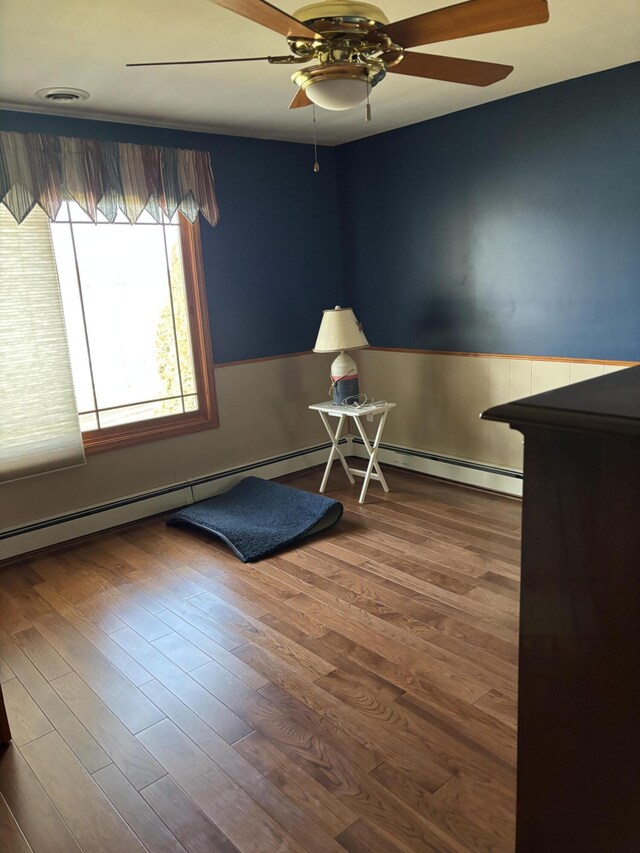 interior space featuring ceiling fan, visible vents, and wood finished floors