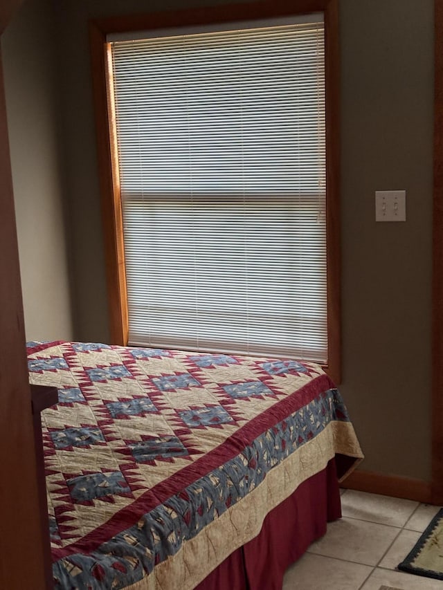 bedroom with light tile patterned floors and baseboards