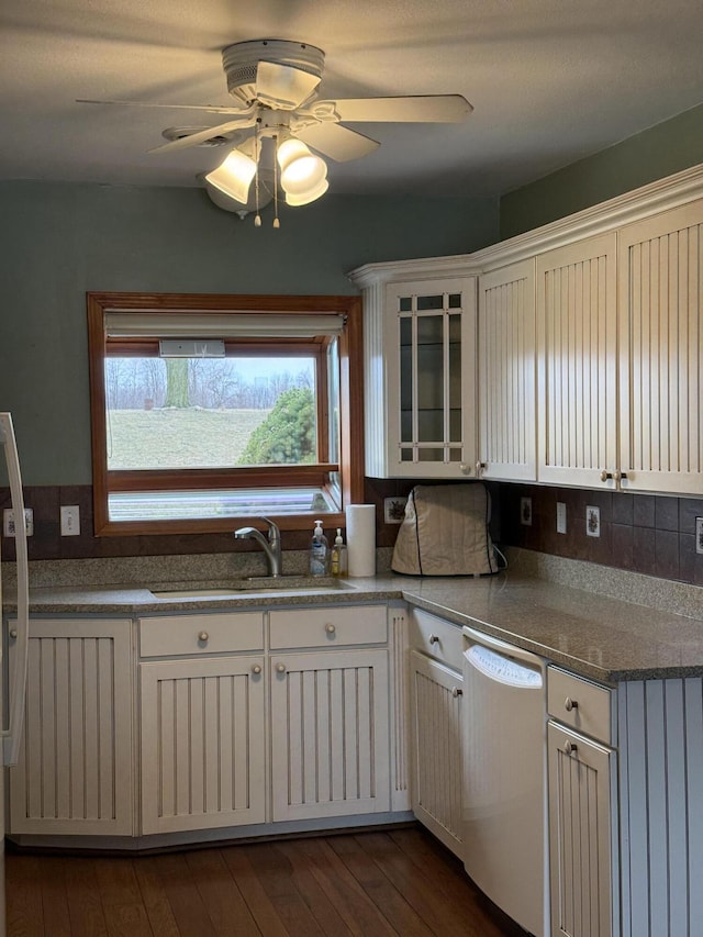 kitchen featuring dark wood-type flooring, a sink, white cabinets, dishwasher, and ceiling fan