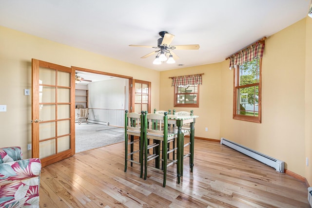 222 Crockett Dr, Quincy, MI 49082 - dining room featuring baseboard heating, a ceiling fan, light wood finished floors, a baseboard heating unit, and plenty of natural light