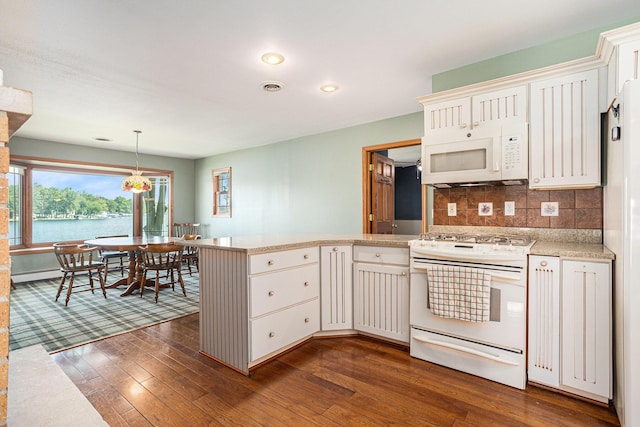 222 Crockett Dr, Quincy, MI 49082 - kitchen featuring white appliances, a peninsula, dark wood-style flooring, decorative backsplash, and recessed lighting