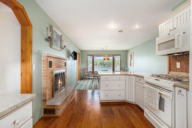 222 Crockett Dr, Quincy, MI 49082 - kitchen with white appliances, a peninsula, recessed lighting, dark wood-type flooring, and white cabinetry