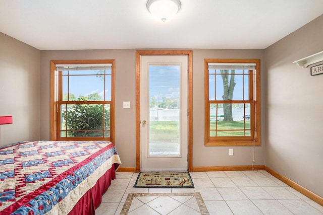 222 Crockett Dr, Quincy, MI 49082 - bedroom with multiple windows, light tile patterned flooring, inlaid floor details, and access to exterior