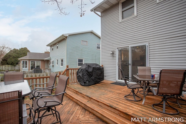 wooden terrace with outdoor dining area and area for grilling