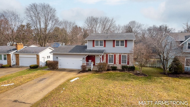 traditional-style home featuring a garage, driveway, brick siding, and a front yard