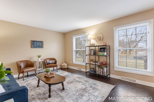 living area featuring wood finished floors, visible vents, and baseboards