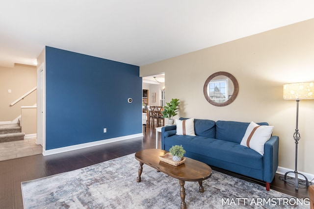 living area with stairway, wood finished floors, and baseboards