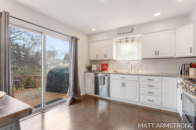 kitchen with white cabinets, dark wood finished floors, gas range, stainless steel dishwasher, and backsplash