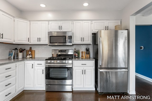 kitchen with white cabinets, dark wood-style floors, stainless steel appliances, and backsplash