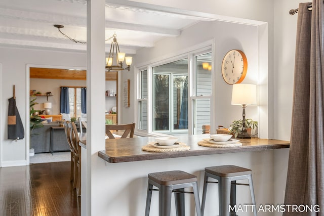 kitchen with dark wood-type flooring, a healthy amount of sunlight, beamed ceiling, and a notable chandelier