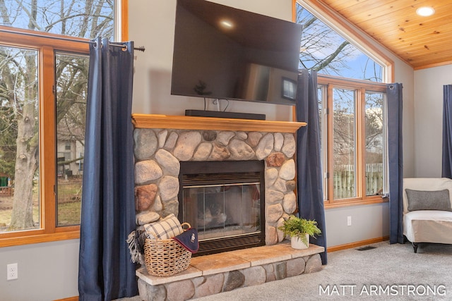 details with visible vents, baseboards, wooden ceiling, carpet, and a stone fireplace