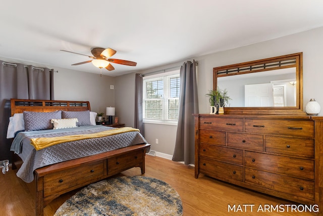 bedroom featuring light wood-style floors, visible vents, baseboards, and a ceiling fan