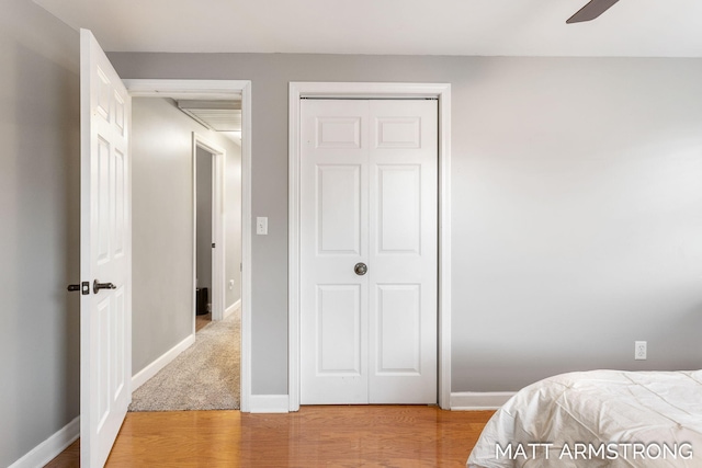 bedroom with ceiling fan, a closet, baseboards, and wood finished floors