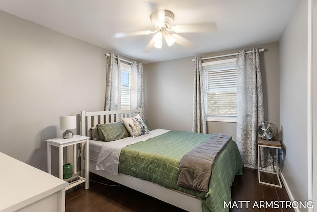 bedroom featuring dark wood-type flooring, a ceiling fan, and baseboards