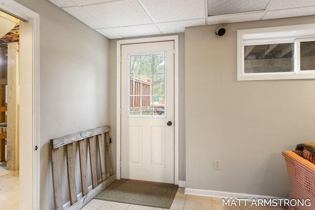 entryway featuring a paneled ceiling, baseboards, and tile patterned floors