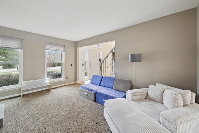 living area with visible vents, stairway, carpet, and baseboards