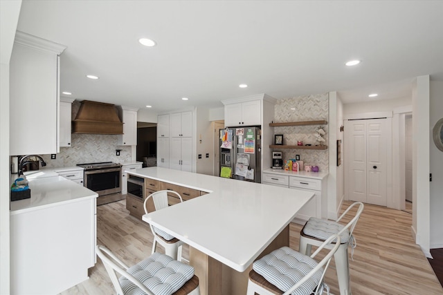 kitchen featuring a kitchen island, a sink, light countertops, custom range hood, and appliances with stainless steel finishes