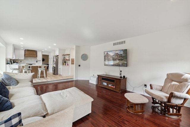 living area featuring recessed lighting, visible vents, baseboards, and wood finished floors