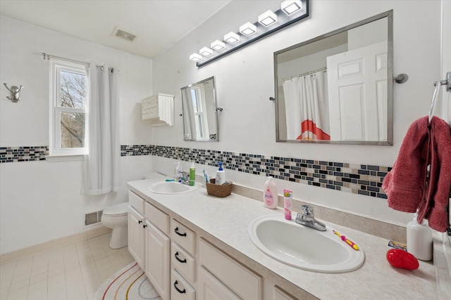 full bath with a sink, visible vents, and toilet