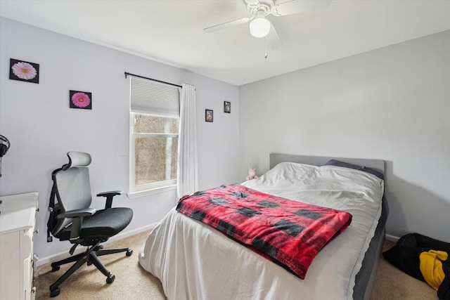 bedroom featuring baseboards, light colored carpet, and ceiling fan