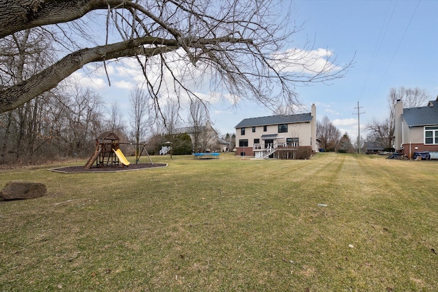 view of yard featuring a wooden deck and playground community