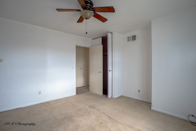 unfurnished bedroom featuring light carpet, baseboards, visible vents, and ceiling fan