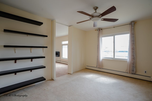 unfurnished room with a healthy amount of sunlight, a baseboard radiator, and light colored carpet