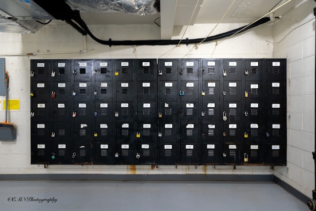 interior space featuring finished concrete flooring and concrete block wall