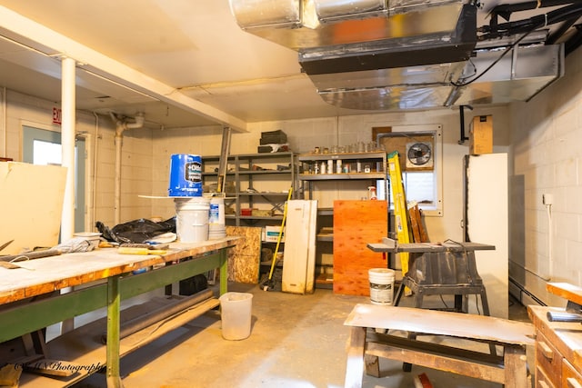 basement with a workshop area and concrete block wall