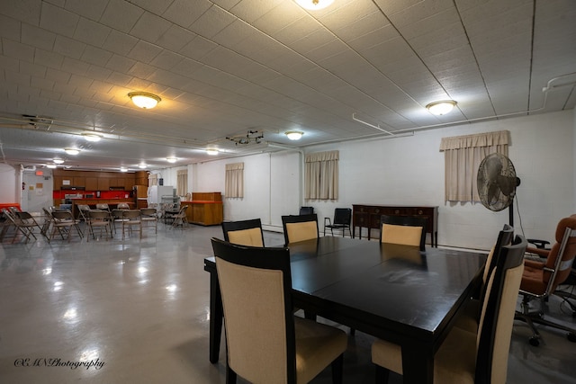 dining room with finished concrete floors and concrete block wall