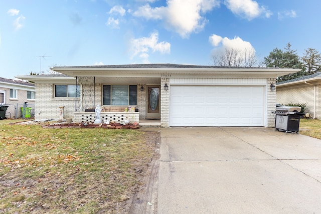 ranch-style home with driveway, a front lawn, an attached garage, and brick siding