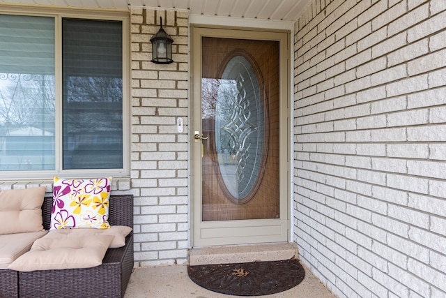 view of exterior entry featuring brick siding